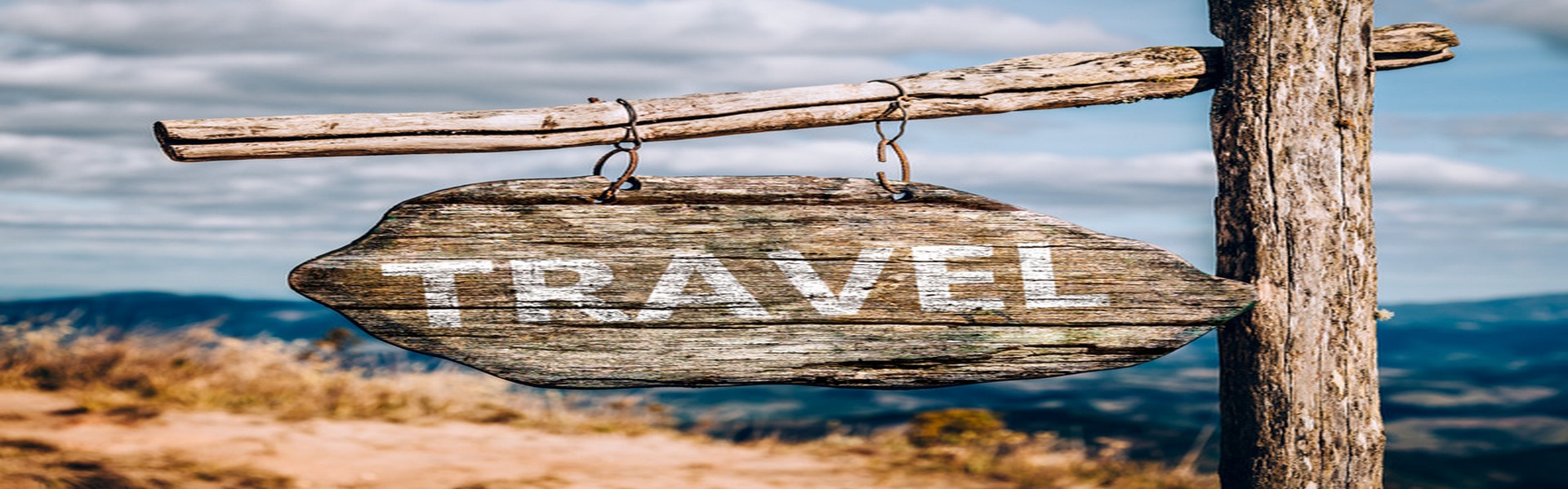 Travel text on a wooden sign board.